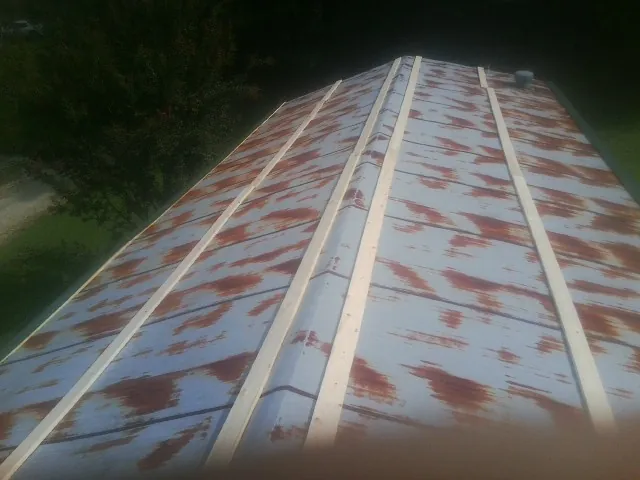 Rusted metal roof panels with new wood purlins before replacement — Storm Damage Roof Repair in Courtland by Roofing Brothers